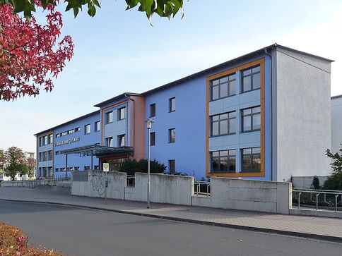 blaues Schulgebäude mit der Aufschrift Gymnasium Coswig an der Fassade