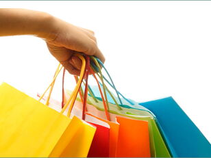 Symbolbild Einkaufen - Hand mit Papiereinkaufstüten