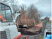 Reparatur des Grenzweges - Bagger verteilt Mineralgemisch