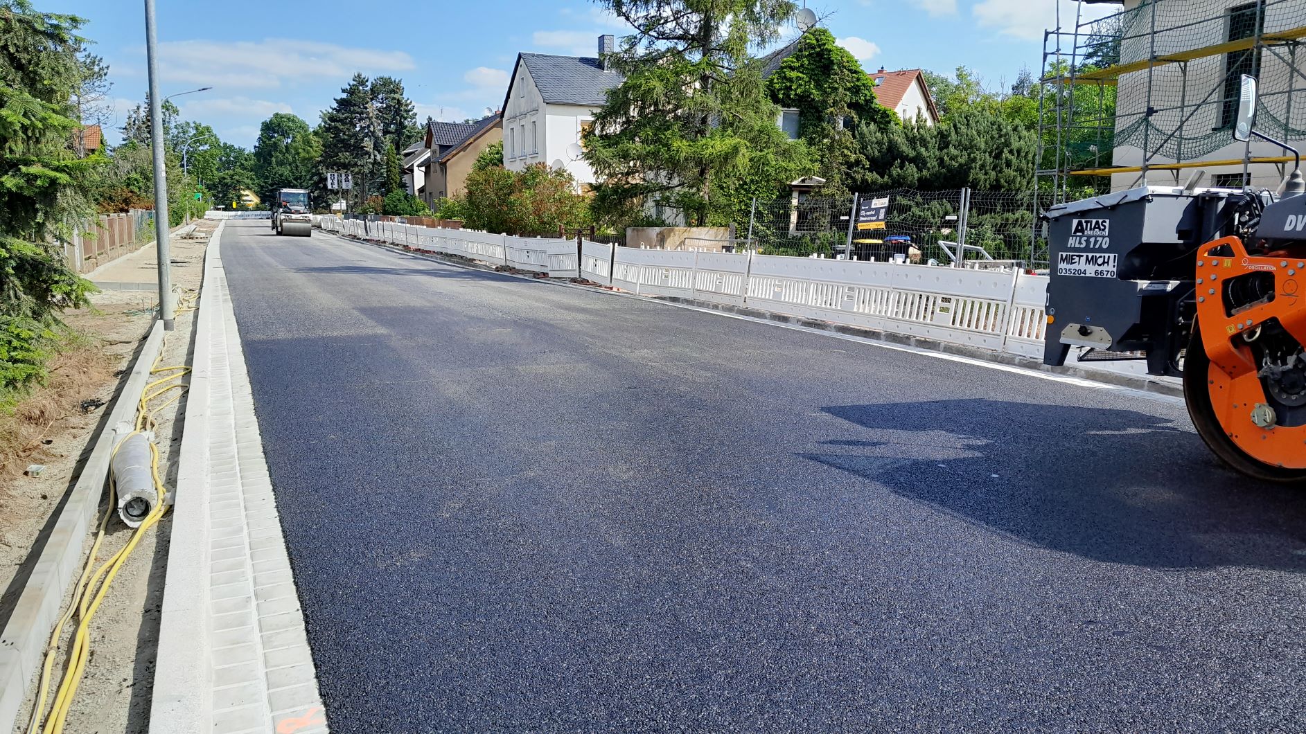 frischer Asphalt und Baufahrzeuge