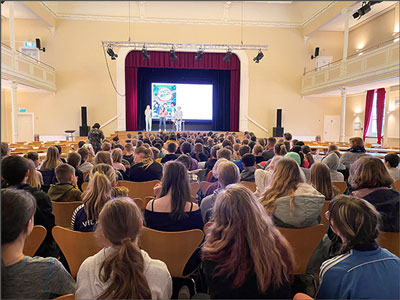 viele Kinder sitzen in der Börse und schauen zur Bühne