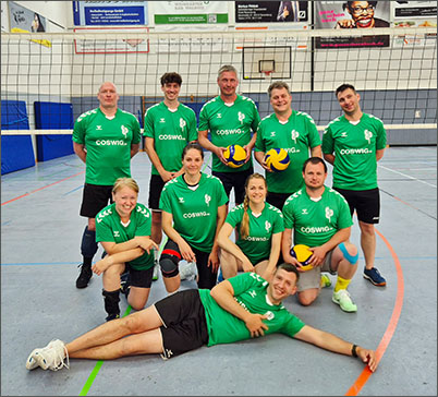 Eine Gruppe von Volleyballerinnen und Volleyballern aus Coswig sind in einer Sporthalle.