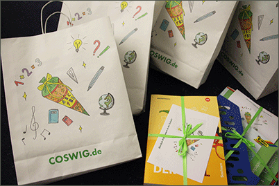 Papiertüten mit Schulmotiven und Coswiger Schriftzug, Schulbücher und Schreibmaterial für die Erstklässler