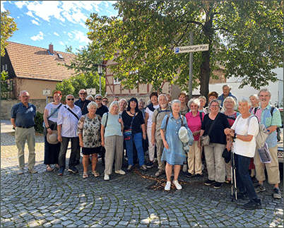 Eine Gruppe steht vor dem Ravensburger Schild am Ravensburger Platz.