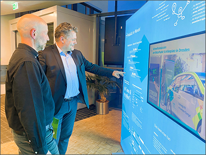 Oberbürgermeister Thomas Schubert und Klimaschutzmanager Jürgen Wellerdt stehen vor einer Ausstellungswand.