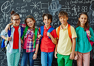 Kinder stehen vor beschrifteter Schultafel