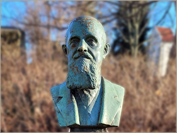 Carl-Romer-Denkmal in Coswig - im Hintergrund Alte Kirche Coswig